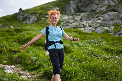 Woman hiking on a trail in the mountains, active holiday concept
