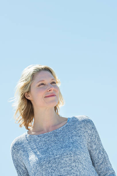 istock Woman Looking Away While Smiling Against Clear Sky 176538280