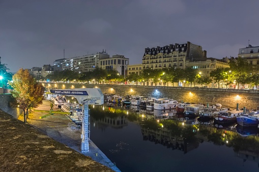 Paris, France. Port of Paris, Arsenal at night. Bassin de l'Arsenal. Boat basin that connects the Canal Saint-Martin, which begins at Place de la Bastille, to the Seine, at Quai de la Rapé