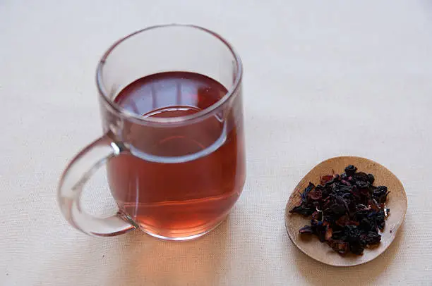 Dried Herbs and Fruits Preaparation in a bowl and Herbal Tea in a cup.