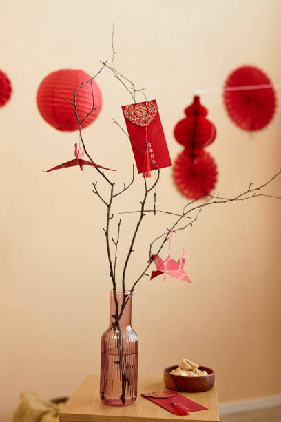 istock Tree branches decorated with paper cranes and red envelopes for Chinese New Year 1765418615
