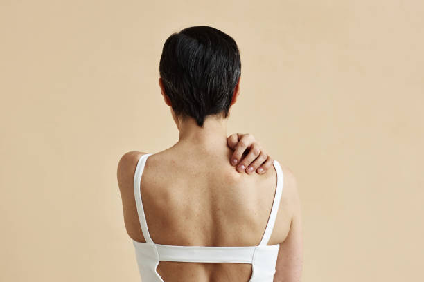 istock Woman hiding standing with bare back against minimal beige background 1765432646