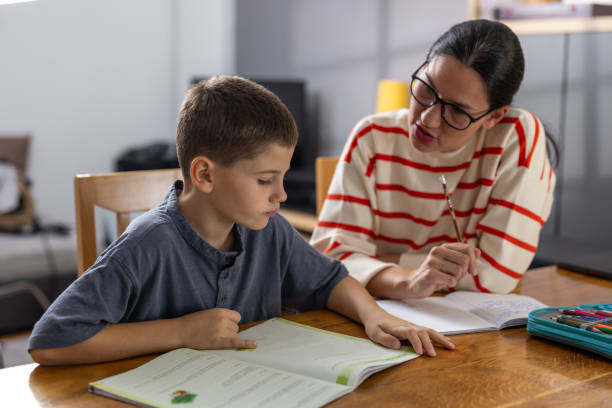 istock Mom assisting son with homework 1765432650