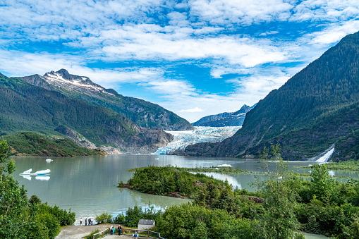 The Majestic Rockies of Canada. The Lake Bow is surrounded by cliffs and glaciers. Beautiful deer with branching horns resting on the shore. Windy autumn day. The concept of active and photo tourism