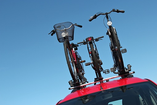 bicycle rack on top of red car