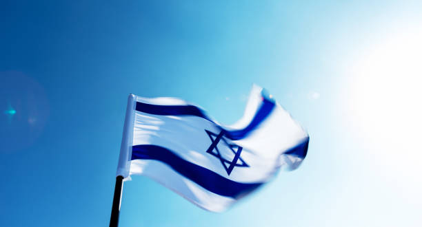 istock Israel's national flag flying in the wind, against blue sky 1765474700