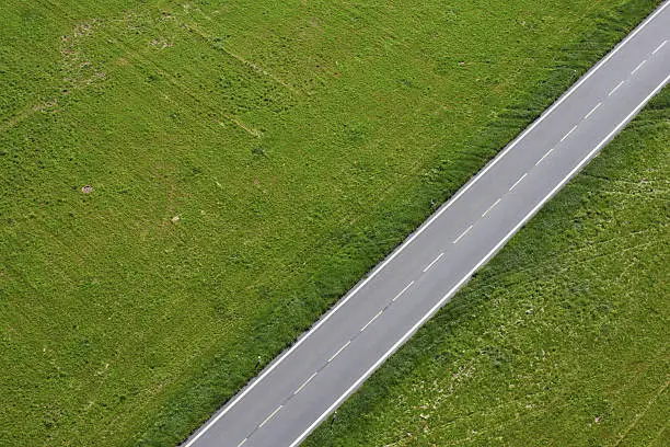 Aerial view of road between green meadow - copy space
