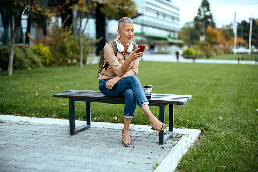 Beautiful  woman smiling outside with mobile phone