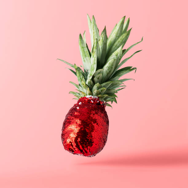 istock Creative fruit concept. Pineapple in red glittery evening dress on pink pastel background. 1765509053