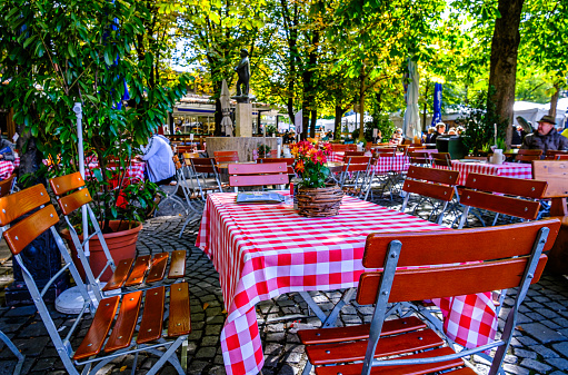 Munich, Germany - October 16: table and chairs at a beergarden at the viktualienmarkt in munich on October 16, 2023