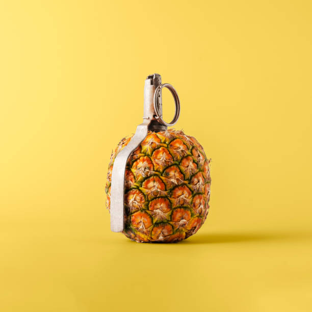 istock Creative fruit concept. Pineapple shaped pomegranate with fuse on yellow background. 1765530522