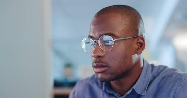 istock Serious black man, computer and focus for research, project deadline or trading at office. African male person, designer or employee working on PC or reading email, information or tasks at workplace 1765546951