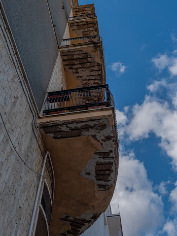 Sanierungsbedürftige Balkone an einem alten Gebäude in Olbia, Sardinien, Froschperspektive