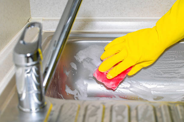 istock hand in a yellow glove washes a kitchen sink with a sponge. 1765570386
