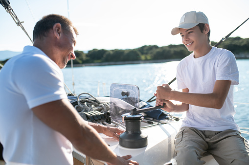 Leisure. Son and dad yachting and looking happy and contented