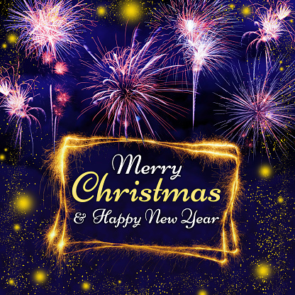 Merry Christmas and Happy New Year lettering on a night blue sky background with lots of beautiful fireworks and glowing lights. Frame made of sparkler trace.