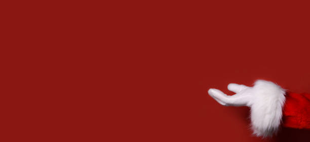 istock Santa Claus hand presenting your text, product, advertisement on a red background.Mockup. Copy space. 1765612643