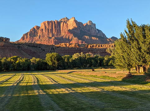 Sunset over Zion National Park as seen from Grafton Road in Rockville Utah along irrigation system and fence by pasture