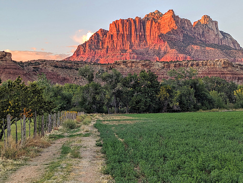 Sunset over Zion National Park as seen from Grafton Road in Rockville Utah along irrigation system and fence by pasture