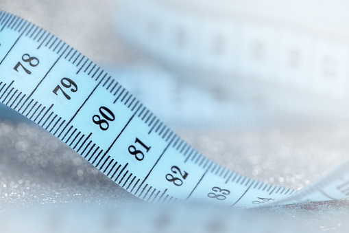 Close-up of tape measure on a sparkling background. Shallow depth of field, space for copy.
