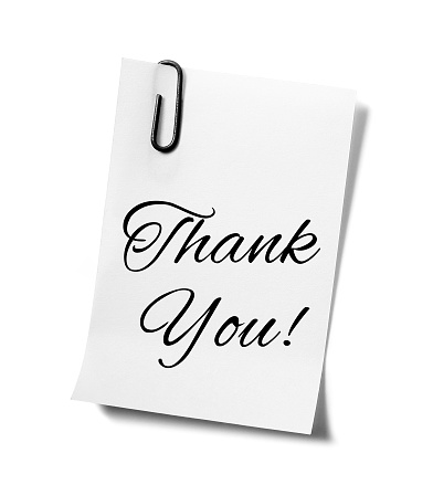 'Thank you' written on a paper note held with a paper clip. Isolated on a white background.