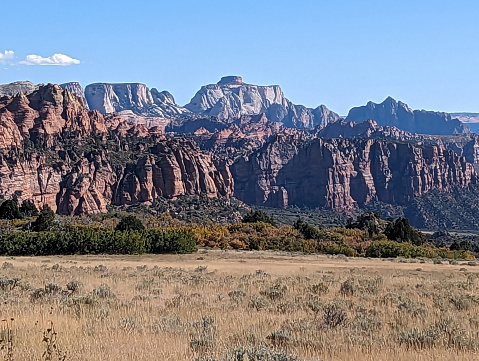 Dry meadows and red rock cliffs along Kolob Terrace Road near Kolob Terrace in Zion National Park Utah overlooking The West Temple in the background