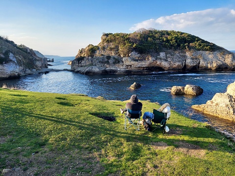 Couple watching the sea view sitting on chairs at sunset