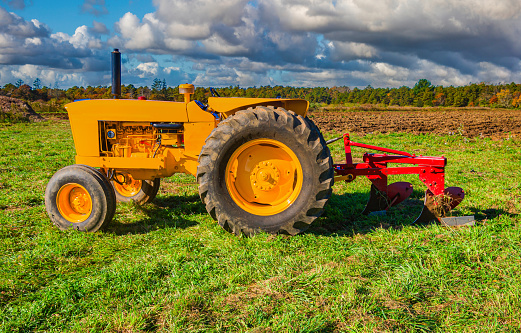 red old rusty tractor in a field