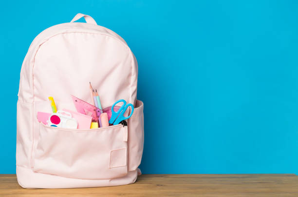 istock Pink school backpack with stationery on wooden table 1765692452