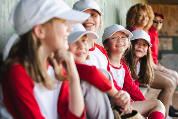 istock Seated in the dugout are six elementary school students, donning baseball team uniforms. 1765701741