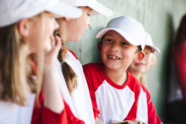 istock Six elementary school-aged children are in the dugout, dressed up in baseball team uniforms. 1765701851