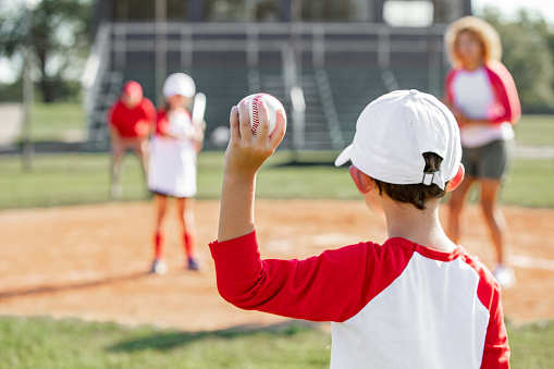Pitching a ball, baseball and person outdoor on a pitch for sports, performance and competition. Professional athlete or softball player for a game, training or exercise challenge at field or stadium