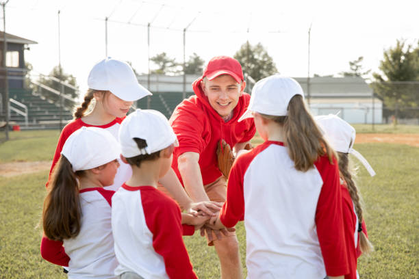 istock A baseball coach, along with his young team, gathers in a huddle, placing their hands together 1765702266