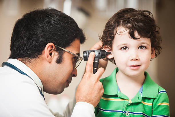 medico esaminando un piccolo orecchio ragazzi - esame otorino foto e immagini stock