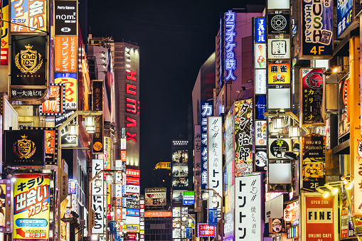 Tokyo, Japan - April 11, 2023: main street of Kabukicho with illuminated neon lights at night. Kabukicho is a famous entertainment district in Shinjuku with many movie theaters hostess clubs and love hotelsTokyo,