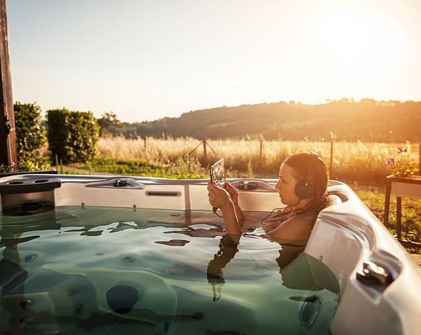 mujer en la bañera de hidromasaje con jacuzzi con tableta digital - tourist resort audio fotografías e imágenes de stock