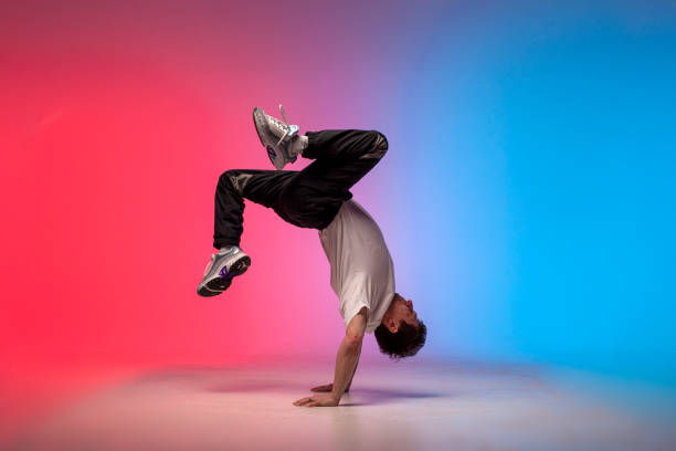 istock young guy dancer is dancing break in neon lighting, male acrobat is doing trick and dance exercise 1765742150