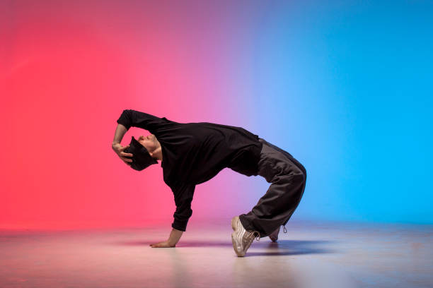 istock young guy dancer in black clothes break dancing in neon lighting, man performs hip hop movement in red blue club 1765742158