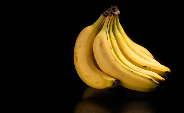 istock Bananas, a beautiful composition with bananas on a reflective surface with a dark background, selective focus. 1765749640