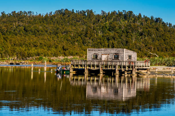 a histórica casa de barco de madeira na lagoa okarito perto de franz josef na costa oeste da ilha sul - okarito lagoon - fotografias e filmes do acervo