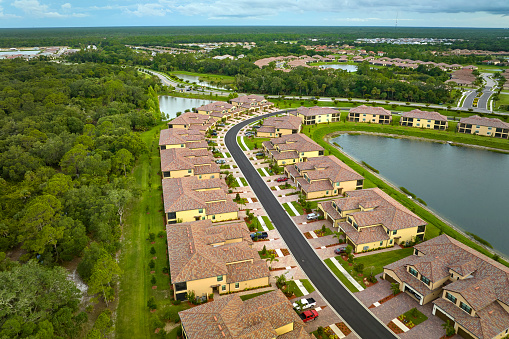 Aerial view of tightly located family houses in Florida closed suburban area. Real estate development in american suburbs.