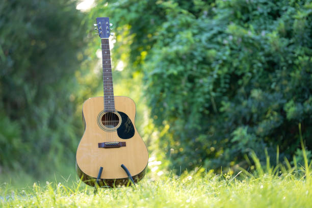 istock Acoustic guitar outdoors on greenery background. Concept of calm music 1765760607