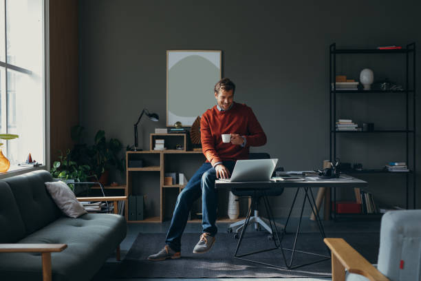 istock A Happy Handsome Businessman Holding A Cup Of Coffee While Working On His Computer 1765761808