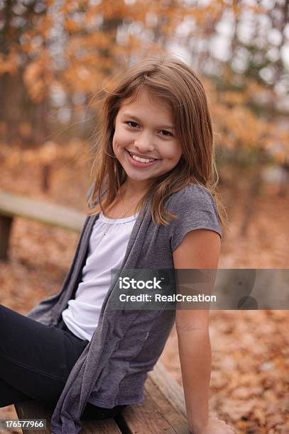 Foto de Garota Sorridente Com Dimples Sentar Ao Ar Livre Durante O Outono Nos Eua e mais fotos de stock de Covinha