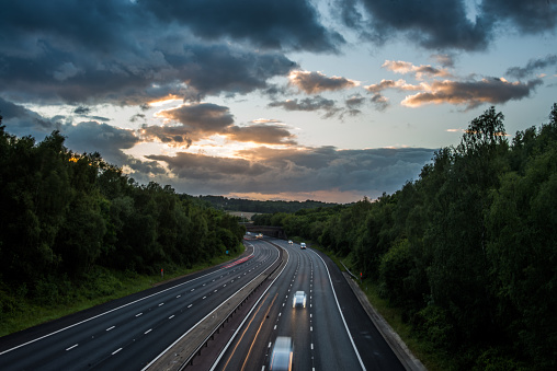 This captivating image showcases the M27 motorway in the UK under the soft glow of high dynamic range (HDR) photography. Light traffic gently flows along the lanes, creating a serene and tranquil scene.