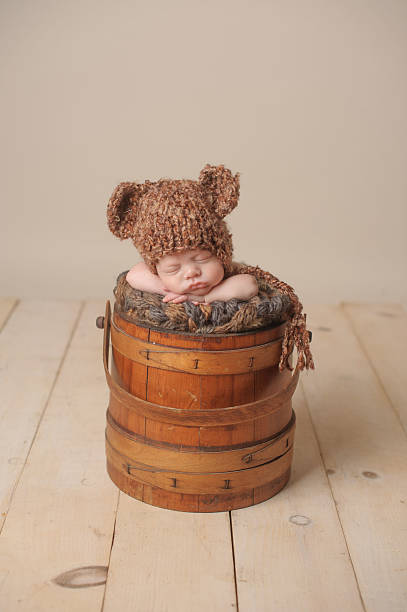 menino dormir peacefull recém-nascido em um chapéu de malha balde com urso - peacefull - fotografias e filmes do acervo