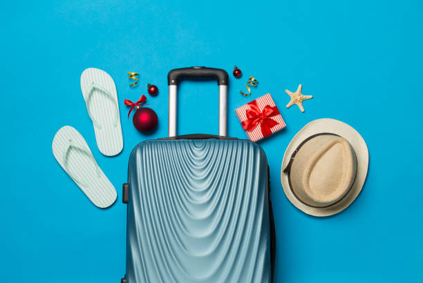 istock Suitcase, gift box, flip flops on color background, top view 1765839627