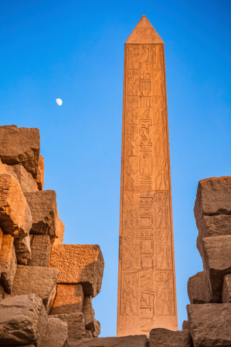 The Obelisk of Hatshepsut by sunset with moon. It is the tallest obelisk still standing in Egypt and one of two still standing at Karnak. It is 97 feet high, and is 320 tons of solid Aswan granite.