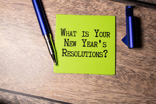 istock Top View Of Office Desk and Notepad With Text - What is Your New Year's Resolutions. 1765861090