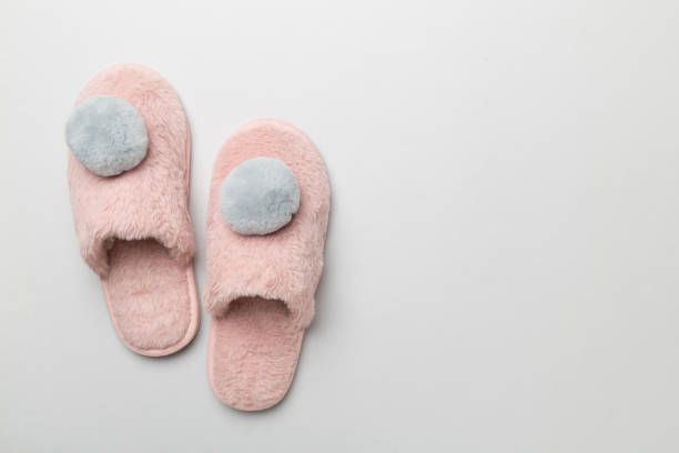 istock Soft pink slippers on color background, top view 1765862775